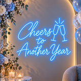 Blue Cheers to Another Year neon sign on a party backdrop