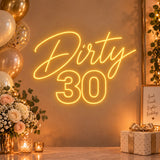 Gold Dirty 30 neon sign on a birthday party wall