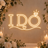 I Do neon sign with ring and heart accents glowing in warm white