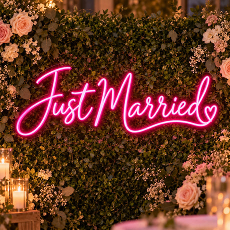 Pink Just Married neon sign on a flower wall wedding backdrop