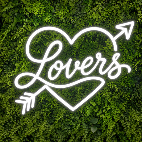 White Lovers neon sign with heart and arrow on a green wall