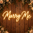 Marry Me neon sign on a wooden wall for a wedding proposal