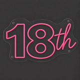 Pink 18th birthday neon sign lit on a dark gray background