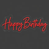 Red Happy Birthday neon sign lit on a dark gray background